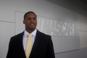Photo portrait of Jusan Hamilton in front of NASCAR sign