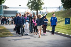 group of students and family members walk behind a student tour guide